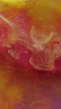 Dikey video. Renkli akış. Sis mürekkebi. Canlı pembe sanat sıvısı ile harmanlanmış zarif sarı kıvrımlı girdap. Parlak cazibe sıvısı soyut arkaplanı çözdü.