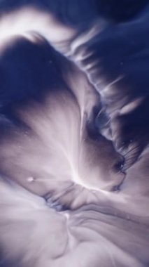 Dikey video. Mürekkep akışı. Boya akışı. Soyut sanat arka planında yüzen mavi beyaz renkli su dalgası kimyasal diş minesi akrilik sıvısı.
