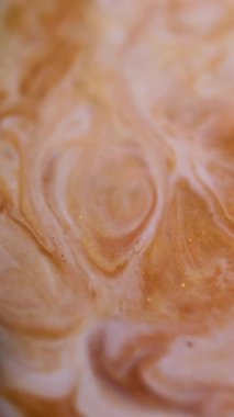 Dikey video. Dalgalı boya. Parlak sıvı. Bulanık altın sarısı beyaz mermer desenli kimyasal sıvı akrilik soyut arkaplanda yayılıyor.