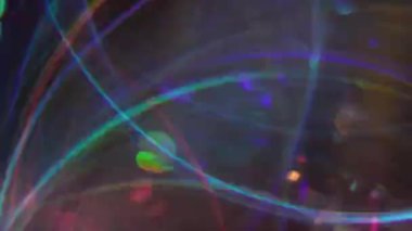 Çok renkli ışınlar. Bulanık parıltı. Sarı mavi turuncu mor iplikler soyut parlak kaleydoskop ışık arka planında hareket ediyor.