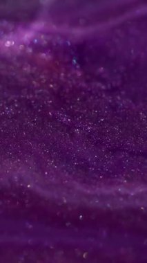 Dikey video. Karışım sıvısı. Bokeh dokusu. Odaklanmamış mor parıltılı boya su sıvısı kimyasal emülsiyon soyut sanat arka planına yayılıyor.