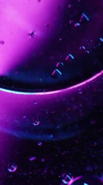 Dikey video. Sıvı baloncuk. Hyaluronik asit. Soyut sanat ışığı arka planında yüzen mavi mor neon renkli yuvarlak kimyasal sıvı.
