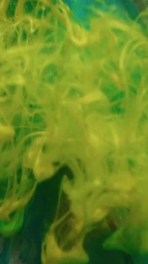 Dikey video. Renk sıçraması. Piramit arka planı. Odaklanmamış sarı bronz sıvı doku, soyut yaratıcı sanatta yüzen boya sisi..