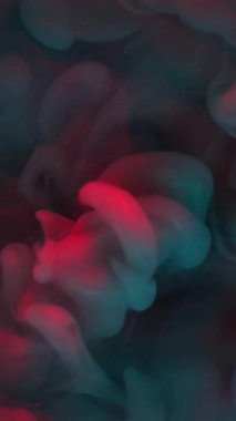 Dikey video. Duman patlaması. Mistik boya. Gri, mavi, parlak dalga koyu suda akıyor. Odaklanamayan renkli soyut arkaplan.