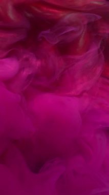 Dikey video. Duman dalgası. Sanat sıvısı. Siyah su yüzeyinde pembe, parlak kırmızı neon boya patlaması. Soyut duman sıçrama renk dökülmesi çözünmüş arkaplan.