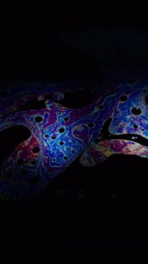 Dikey video. Çok renkli sıvı. Kaotik balon. Neon yağlı boya, sanat sıvısı, yuvarlak portal lenslerini harmanlıyor. Soyut dökülme pigmenti bulanık siyah arkaplan.