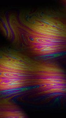 Dikey video. Gökkuşağı sıvısı. Sabun köpüğü. Sanat petrol zemininde neon pigment mürekkep karışımı. Soyut prizma bulanık ışık renk karışımı.