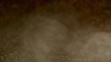 Boya dumanı. Pırıltılı sis. Odaklanmamış bronz renkli su buharı yaratıcı pullar soyut karanlık sanat arka planında hareket ediyor..