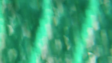 Odaklanamayan akış. Bulanık ışık. Parıldayan mercek parıltısı yeşil mavi bokeh optik soyut sanat arka planında hareket ediyor..