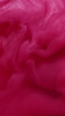 Dikey video. Parlak sıvı. Pigment sıvısı. Pembe mürekkep jeli sabun parıldıyor sanatsal emülsiyon yayılıyor soyut arkaplan girdabı kıvrımlı dalga boyası sisi.