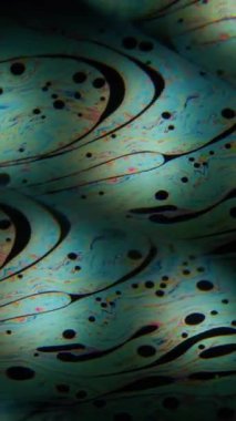 Dikey video. Benzin yağı. Kaleydoskop yağı. Soyut bulanık arkaplan sabununda renkli çift prizma noktası siyah optik efekt.