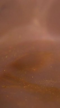 Dikey video. Parçacık suyu. Köpüklü boya. Soyut sanat arka planında çözünmüş sarı turuncu renkli kimyasal su sim sıvısı.