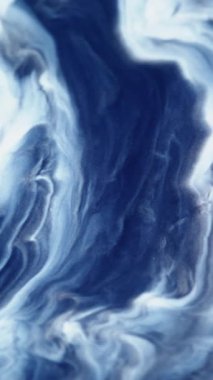 Dikey video. Mermer dokusu. Dalgalı boya. Soyut arkaplanda akan mavi beyaz dalga parçacıkları kimyasal akrilik madde.