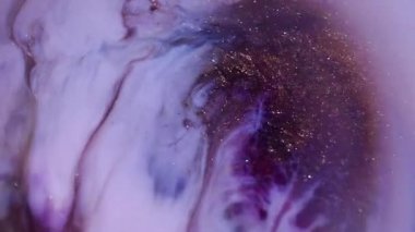 Parlak bir serpinti. Parıldayan sanat. Odaklanamayan sarı mor beyaz mürekkep soyut akrilik arka planda altın rengi yayılıyor..