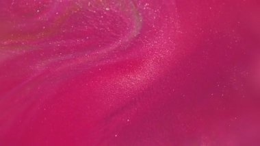 Bulanık boya dökülüyor. Pigment dokusu. Odaklanmamış pembe renk soyut bokeh sanat arka planında akan parlak sıvı emülsiyonu.