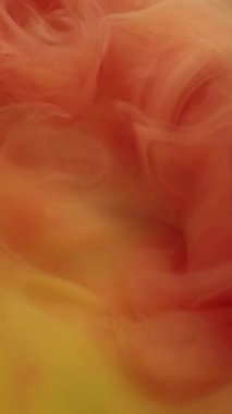 Dikey video. Hipnoz sıvısı. Odaklanamayan akış. Sarı turuncu renkli sarmal duman girdabı. Boyalı su peçesi sıcak, parlak renk arkaplanı harmanlıyor.