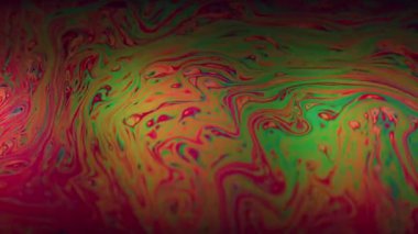 Sabun girdabı. Boya karışımı. Çok renkli benzinli sıvı canlı dalga pigmenti kırmızı pembe arka plan. Soyut parlak benzin sıvısı.