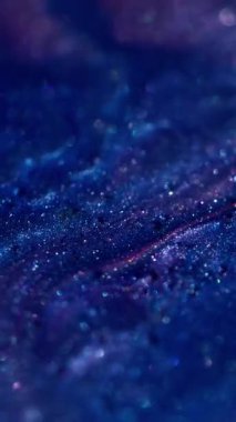 Dikey video. Bokeh baloncukları. Parıldayan su. Odaklanmamış mavi mor renkli yağ damlası. Soyut sanat arka planında yüzen kimyasal mermer sıvısı..
