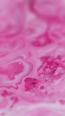 Dikey video. Bokeh parçacıkları. Parlak bir geçmişi var. Soyut sanat eserlerine odaklanmış pembe beyaz renkli boya suyu desenli mermer diş minesi sıvısı.