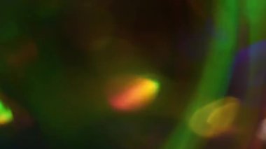 Işık akışı. Odaklanamayan çok renkli doku. Parlak yeşil turuncu mavi mercek Bokeh soyut koyu modern arka planda kıvrılıyor..