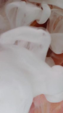 Dikey video. Su açar. Islak çiçek dokusu. Odaklanmamış kırmızı turuncu renkli boya sıvı doğaya sıçramış mürekkep bulutu taç yaprakları soyut sanat arka planı.