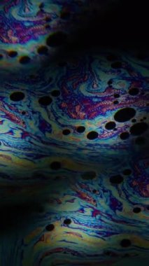 Dikey video. Renkli sıvı. Sanat benzini. Sıvı yağ boyası üzerindeki mercek efekti. Soyut prizma bulanık akış siyah arkaplan.