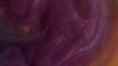 Parıltı dalgası. Mürekkep sıçraması. Odaklanmamış mor turuncu renk. Soyut arka planda yüzen su kimyasalı sisinde parlayan boya..