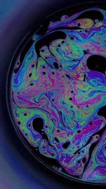 Dikey video. Spektrum sabunu. Boya karışımı. Çok renkli yakıt dokusu. Yuvarlak sanat neon girdap mercek kara bulanık psikedelik soyut arkaplan.