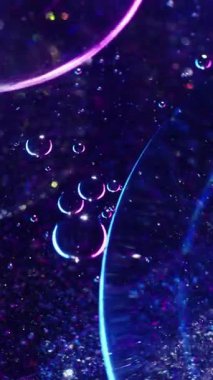 Dikey video. Işık kabarcıkları. Soyut molekül. Odaklanmamış mor neon renkli yağ damlası pulları akrilik arka planda daireler çizen yuvarlak sıvı..