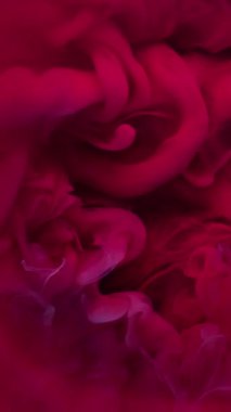 Dikey video. Duman patlaması. Mistik boya. Kırmızı mor dalga fantezi dalgası suda akıyor. Odaklanmamış parlak renk soyut arkaplanı.