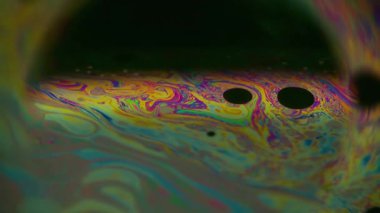 Sabun boyası çözüldü. Yağ pigmenti. Siyah arka planda yarım yuvarlak lens. Soyut yüzen enerjik benzin karışımı çok renkli sıvı parlaklığı.