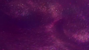 Görüntü mürekkebi. Parlak ışık. Odaklanmamış mor eflatun rengi parlak desen ışıldayan parçacıklar soyut sanat arka planında bokeh etkisi ile birlikte akıyor.
