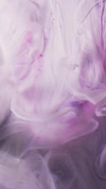 Dikey video. Duman döküldü. Pürüzsüz sis. Su katmanlı beyaz pembe mat sıvı boya. Soyut sanat piramidi yüzey bulanık arkaplan.