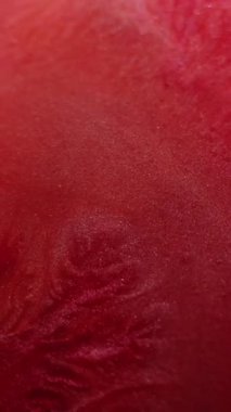 Dikey video. Boya karışımı. Islak doku. Odaklanmamış kırmızı kırmızı renkli su akrilik sıvı mermer parlak akış dalgası soyut sanat arka planına yayılıyor.