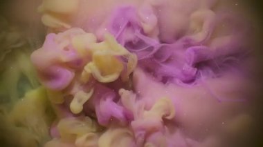 Sis mürekkebi karışımı. Atmosferik duman. Soyut sanat arka planında yüzen kimyasal parıltılı suda bulanık pembe sarı renkli boya..