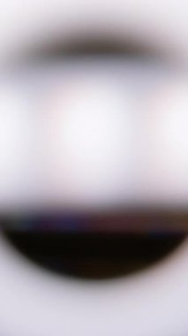 Dikey video. Odaklanmamış lens. Prizma etkisi. Bokeh odak tünel renk spektrumunu çember yapın. Beyaz açık siyah arkaplan gökkuşağı göz çerçevesini örtüyor.