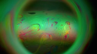 Odaklanmış benzin boyası. Gezegen renk tutulması. Neon küre yeşil girdap siyah arkaplanı harmanlıyor. Kırmızı renk soyut yuvarlak çerçeve.