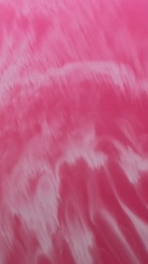 Dikey video. Akrilik karışımı. Sıvı boya. Su dalgası emülsiyonunda çözünmüş kırmızı kırmızı renkli mermer mürekkep soyut sanat arka planına dökülüyor..