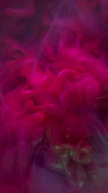 Dikey video. Parıldayan akıntı. Renk patlaması. Sualtı sanatı pırıl pırıl neon patlaması. Boya dumanı pembe mor mor bulanık karışık lekeli damla soyut arkaplan.