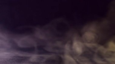 Sis pigmenti. Akrilik doku. Su sisi dumanında çözünmüş neon rengi boya soyut koyu siyah arkaplanda uçuyor..