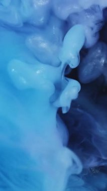 Dikey video. Renkli suluboya. Mürekkep yayıldı. Mor mavi duman bulutu sıvısında gümüş parıltı akıntısı patlar. Fantezi karışık soyut arkaplan.