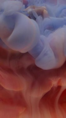 Dikey video. Su açar. Islak çiçek dokusu. Odaklanmamış mavi turuncu renkli bitki sıvısı boya doğanın soyut parlak arka planda yüzmesi..