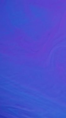 Dikey video. Sıvı doku. Dalga mürekkebi. Suda çözünmüş mavi neon rengi kimyasal boya diş minesi mermer soyut arkaplana yayılıyor.