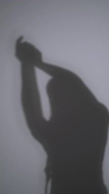 Dikey video. Ruhun iyileşmesi. Uyum dengesi. Güzel bir kadının silueti hipnotik ellerle dans etmekten zevk alıyor. Arka planda yalnız dans ediyor..