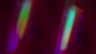 Bulanık holografik spektrum. Kaleydoskop ışınları titreşir. Bokeh ışık soyut arkaplan üzerinde hareket eden yeşil mor neon ışıldayan çok renkli.