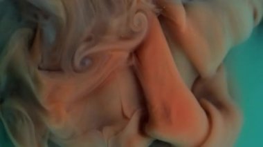 Mürekkebi karıştır. Akan boya. Odaklanmamış yeşil turuncu duman ruhani sis suyu nemli su soyut sanat arka planına kimyasal sıvı sıçratıyor.