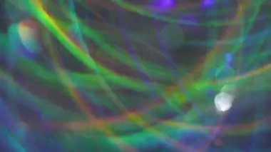 Bulanık sanat pırıltısı. Dönen ışık. Yeşil mavi turuncu çizgiler, çok renkli yanıp sönen mercekler, kaleydoskop şenliği soyut arka planında parıldıyor..