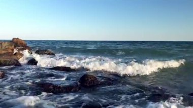 Denizde sörf ve fırtına, kayalarda dalgalar.