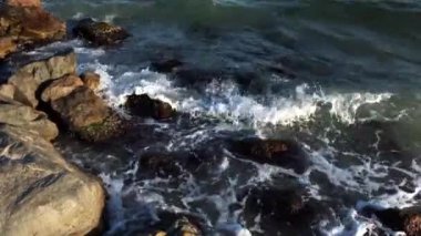 Denizde sörf ve fırtına, kayalarda dalgalar.