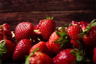 Koyu ahşap arka planda çilekler